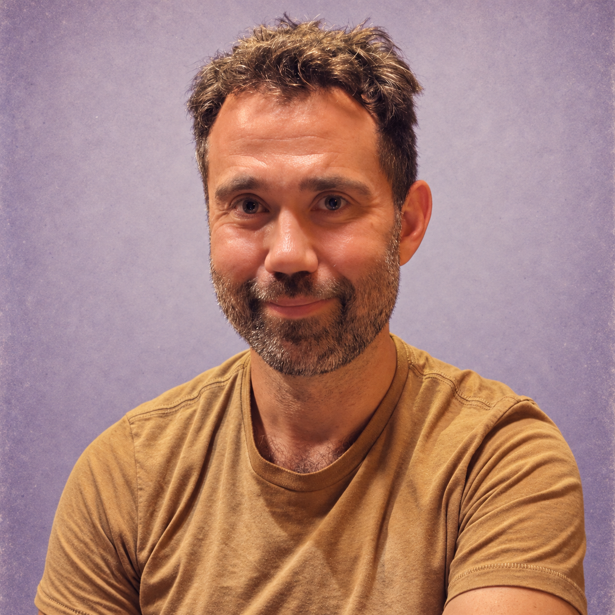Jason with a slight smile, in a softly faded purple photographic portrait
